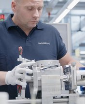 An employee assembles a vacuum pump.