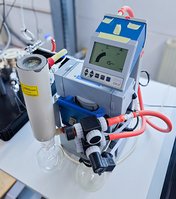 Tisch mit chemiebeständiger Vakuum-Membranpumpe MD 4C mit Glaskolben – im Einsatz für die Manometrische Permeationsprüfung. 