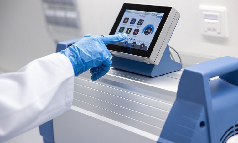 Scientist operating the MD 12C NT VARIO select chemistry diaphragm vacuum pump in a laboratory